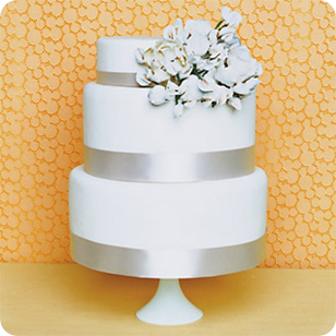 Round Three tier wedding cake with silver ribbon and offset flowers