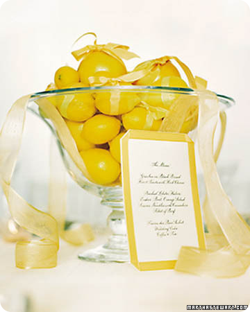 Delicious and bright yellow lemons and grapefruit centerpiece piled high with organza ribbon showcases the event menu; 