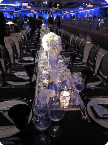 white flowers with black linens and black ghost chairs 